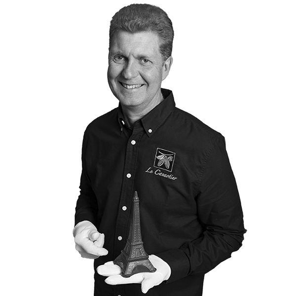 a man holding a small statue of a eiffel tower