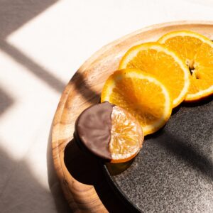 Dégustation d'oranges confites au chocolat noir artisanal dans un décor élégant - Le Cacaotier
